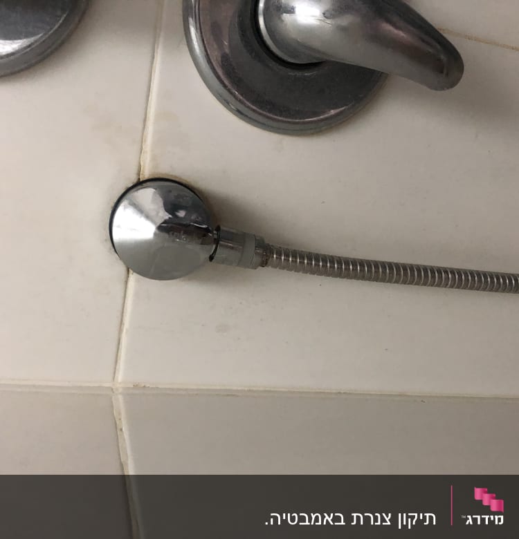 ברז מתכת עם צינור גמיש מחובר לקיר